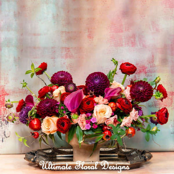 Mixed bouquet of red, pink, and purple flowers in a vase
