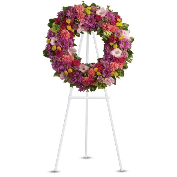 Colorful floral wreath on a white easel stand