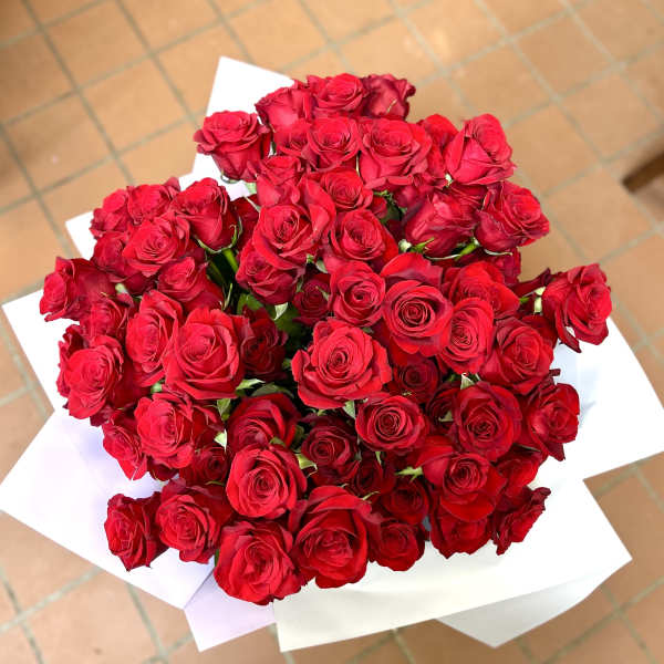 Large bouquet of red roses wrapped in white paper