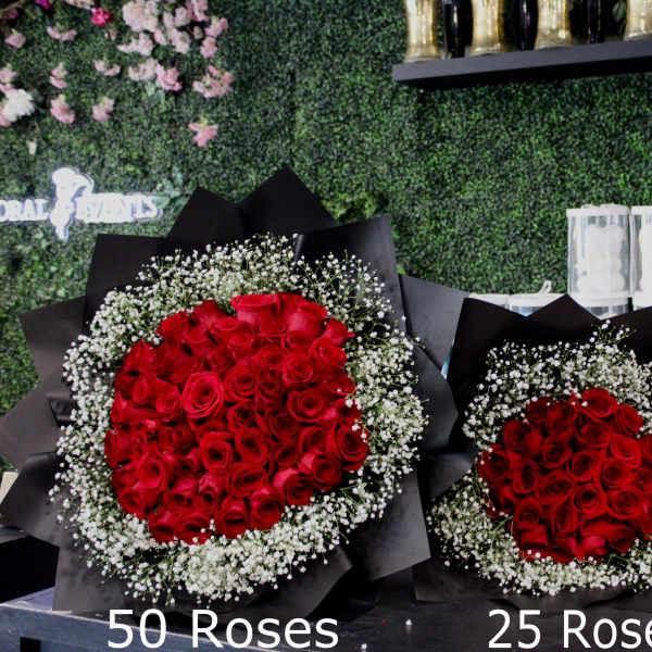 Three bouquets of red roses with baby's breath in black wrap