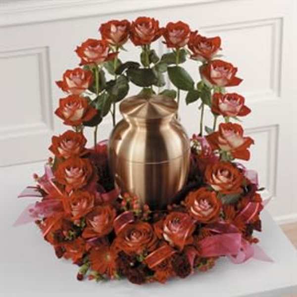 Red roses arranged around a gold urn centerpiece