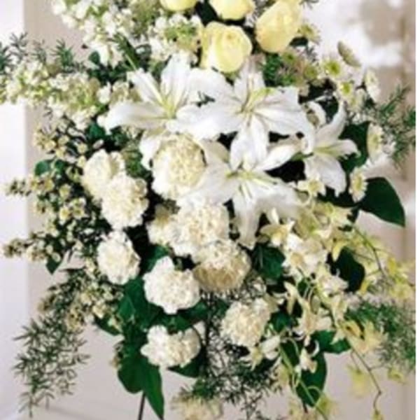 White lilies and pale yellow roses in a standing floral spray