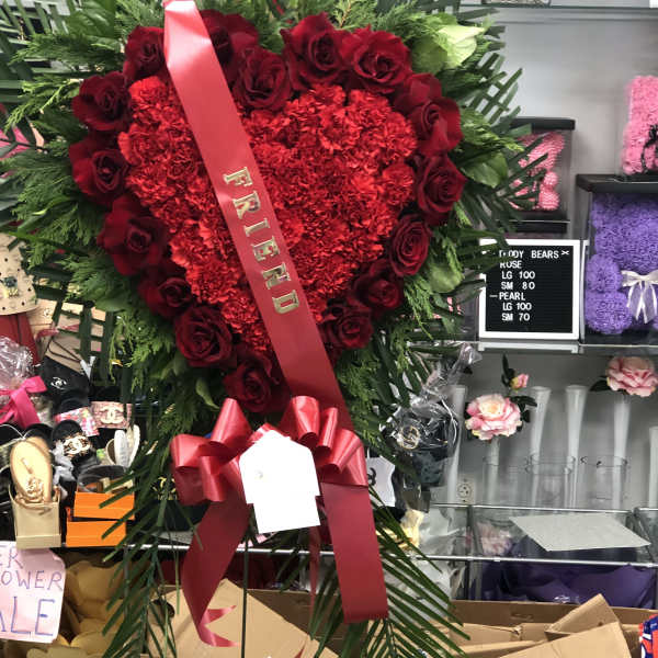 Heart-shaped red rose and carnation standing spray with a ribbon