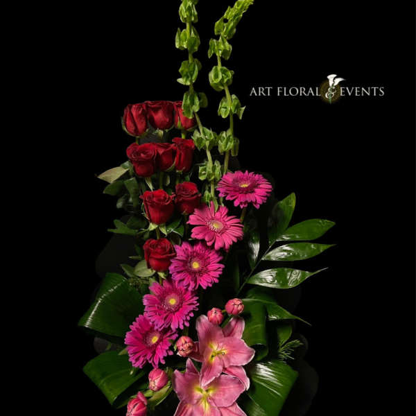 Tall floral arrangement with red roses, pink gerbera daisies, and pink lilies