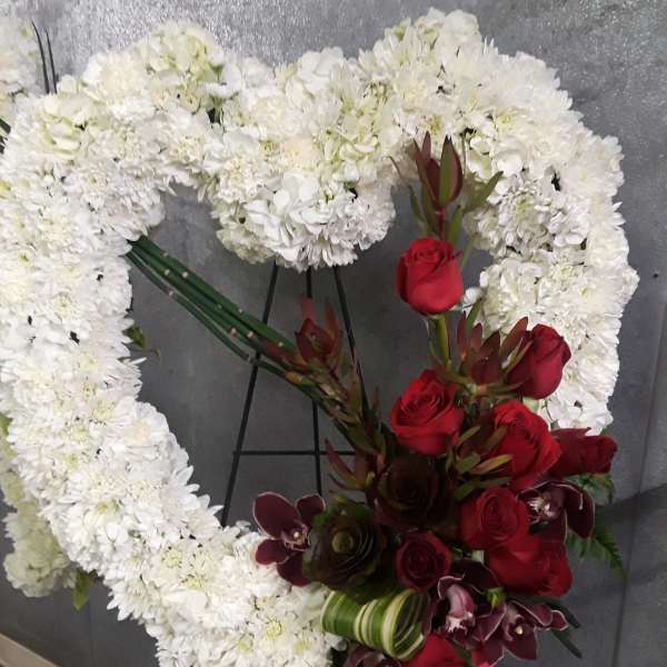 White floral heart wreath with red roses and dark orchids