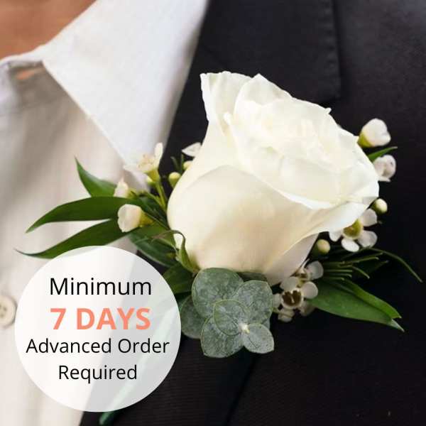 White rose boutonniere pinned to a black suit jacket lapel