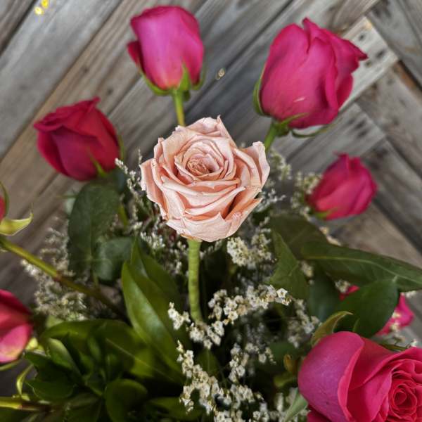 Bouquet of pink roses with a pale peach rose in the center