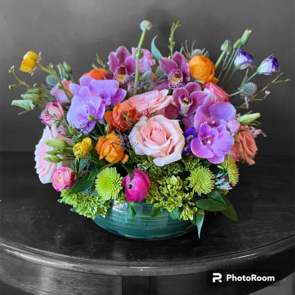 Mixed bouquet of roses, orchids, and green mums in a low glass bowl