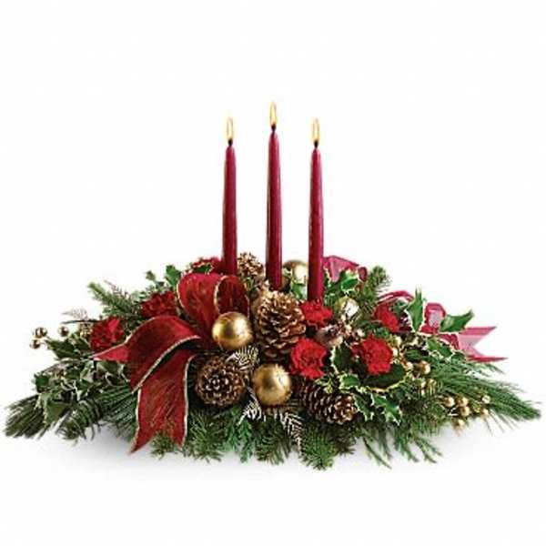 Holiday centerpiece with three red candles, pinecones, and a red ribbon