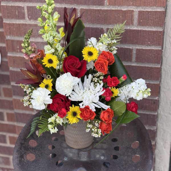 Mixed bouquet in a beige vase with red, white, and yellow flowers