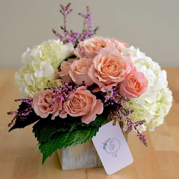 Pink roses and white hydrangeas in a wooden box