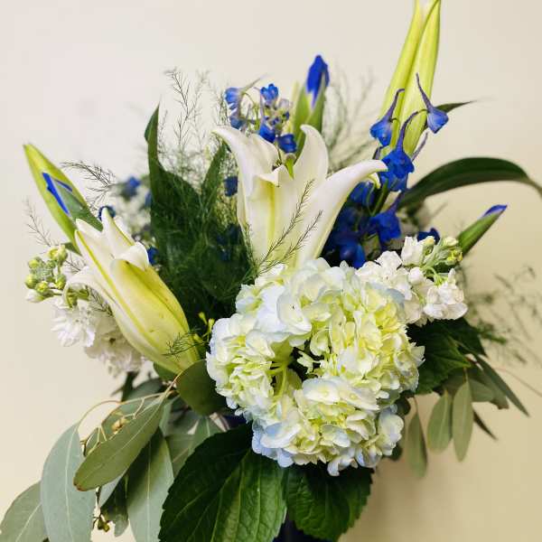 Blue and white floral arrangement in a dark vase