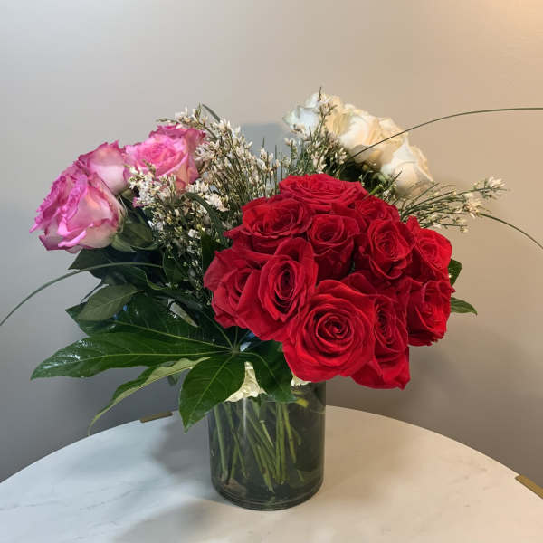 Bouquet of red, pink, and white roses in a glass vase