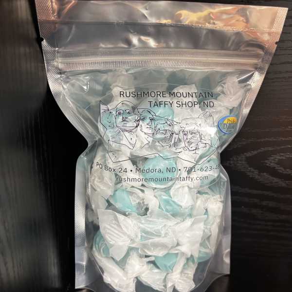 A clear bag of blue and white taffy candy with printed text