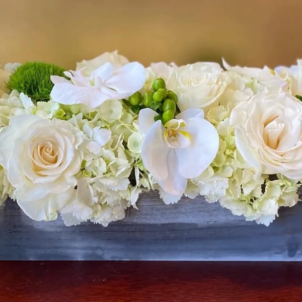 White roses and orchids in a rectangular wooden box