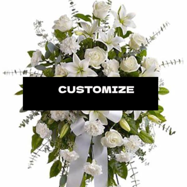 White floral standing spray with lilies and roses on a ribboned easel