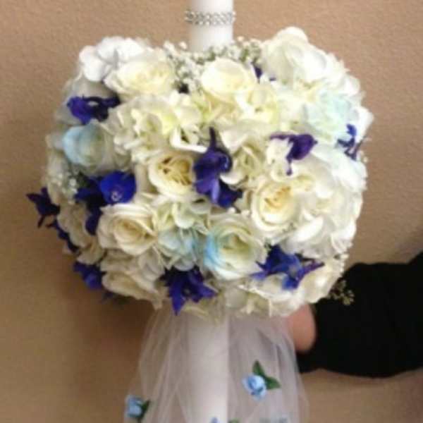 White floral candle with blue accents and tulle drape
