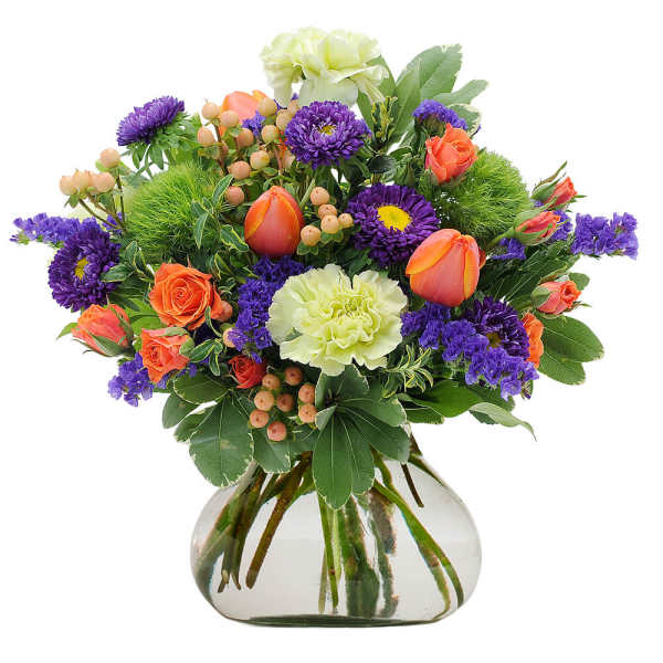 Mixed bouquet of purple, orange, and pale green flowers in a glass vase