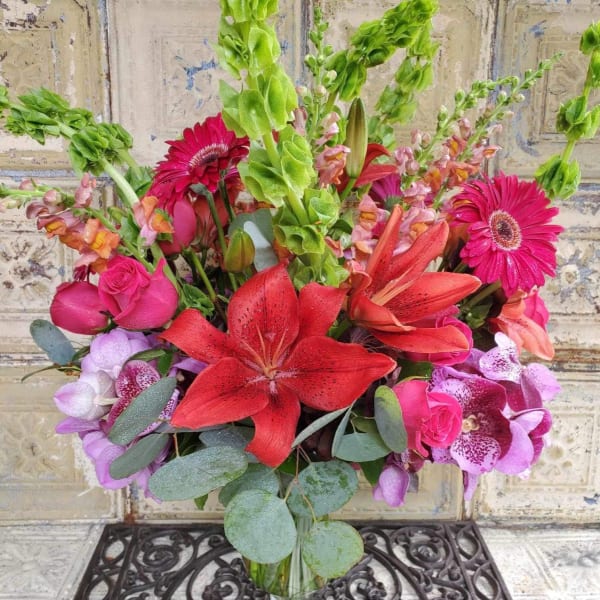 Mixed bouquet with red lilies, pink roses, gerbera daisies, and purple orchids