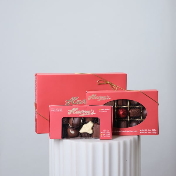 Three boxes of assorted chocolates tied with gold ribbon