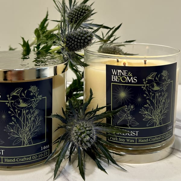 Two scented candles with floral labels and thistle-like stems