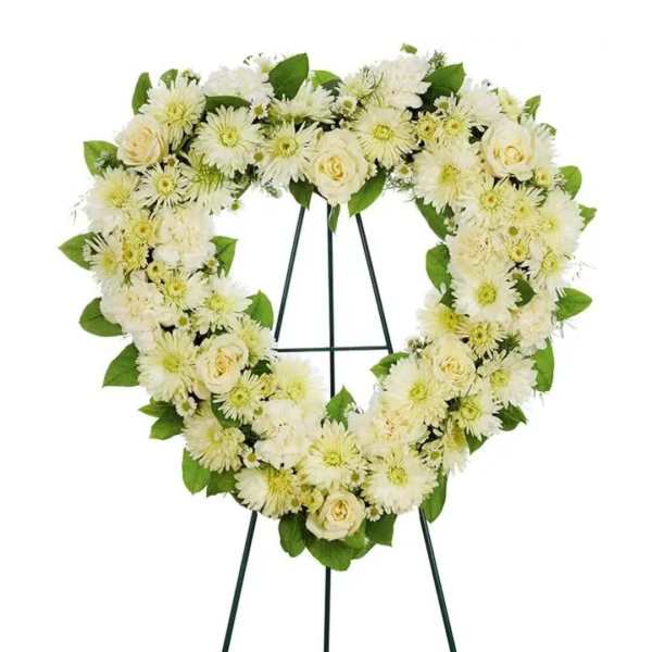 Heart-shaped white floral wreath on a standing easel