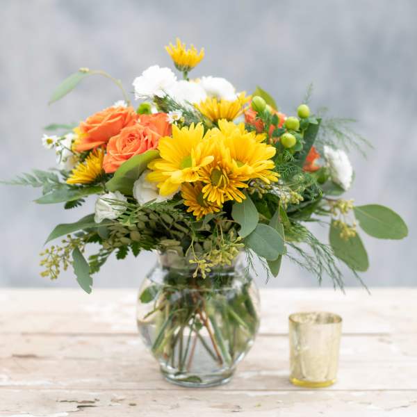 Bouquet of yellow and orange flowers in a glass vase