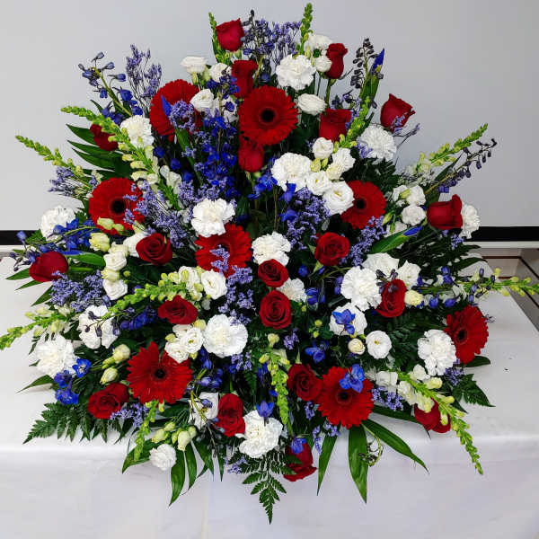 Large red, white, and blue floral spray with roses and gerbera daisies