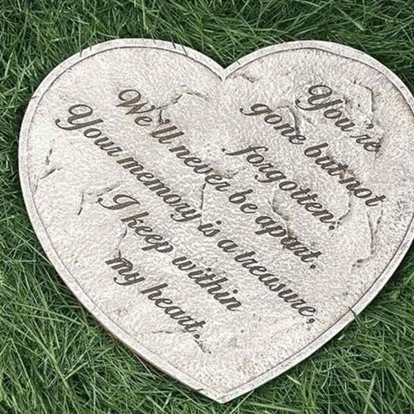 Heart-shaped memorial plaque with an engraved quote on grass