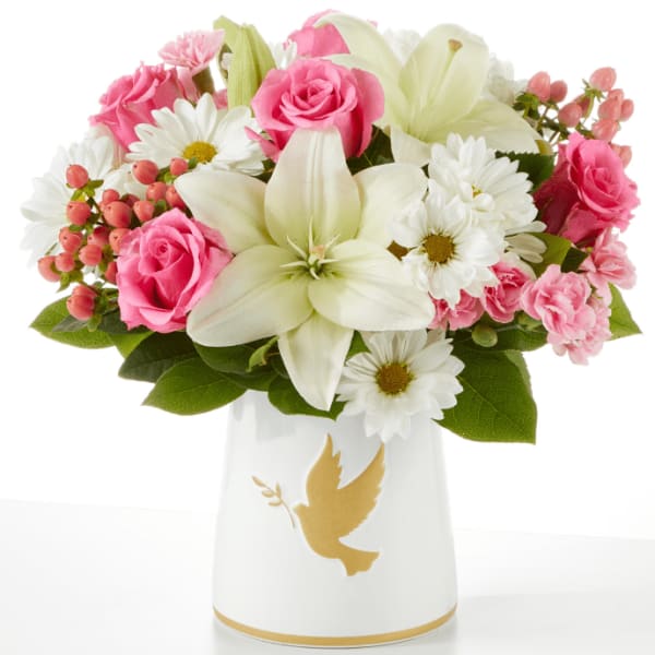 Pink roses and white lilies in a white vase with a gold dove