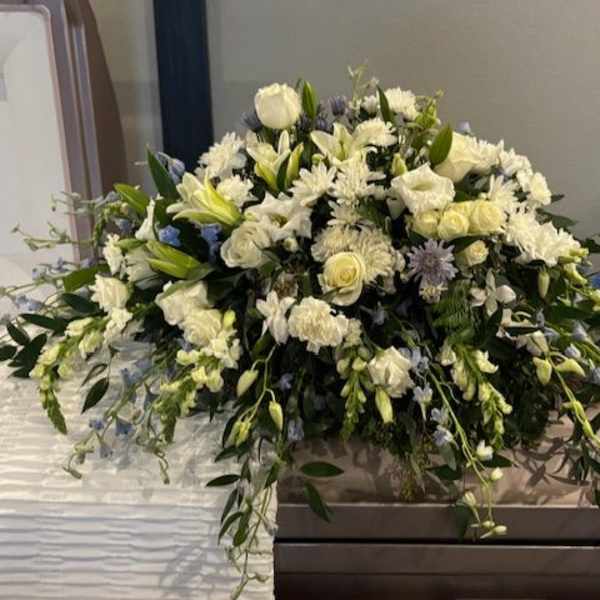 Large white floral spray on a casket
