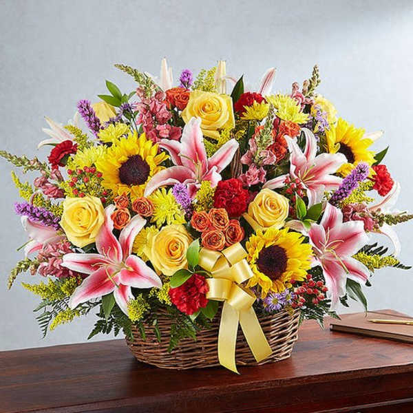 Basket arrangement of mixed flowers with a yellow ribbon