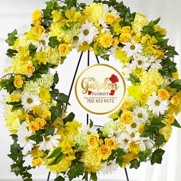 Yellow and white floral wreath on a black stand