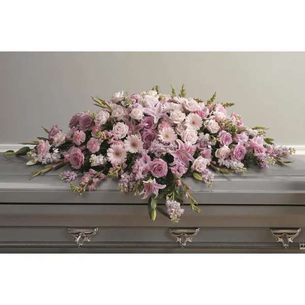 Pink and white floral spray arranged on a casket