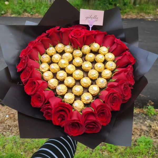 Heart-shaped bouquet of red roses with gold-wrapped chocolates