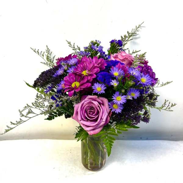 Purple and pink mixed bouquet in a glass vase
