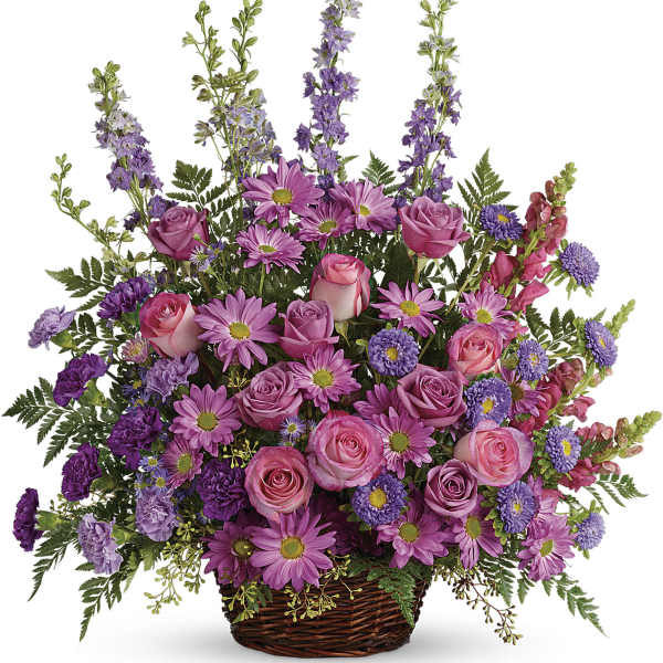 Pink and purple mixed flower arrangement in a wicker basket