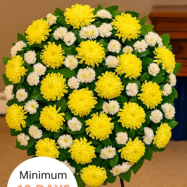 Round standing spray of yellow and white chrysanthemums on a metal easel