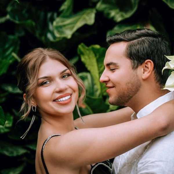 Couple posing with a white calla lily bouquet