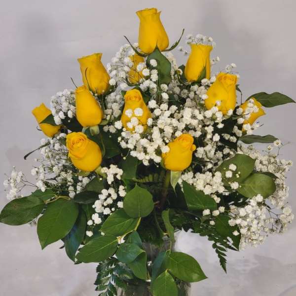 Yellow roses and baby's breath in a clear glass vase