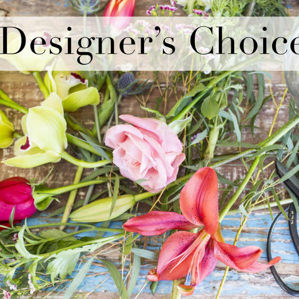 Loose flowers and scissors on a wooden surface with a "Designer’s Choice" sign