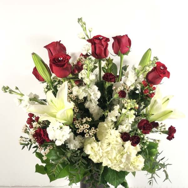 Red roses and white lilies in a dark vase
