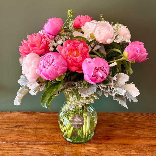 Pink and blush peonies arranged in a glass vase