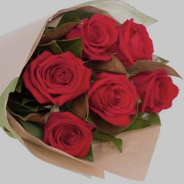 Bouquet of red roses wrapped in tan paper