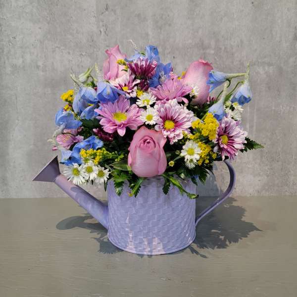 Mixed pastel bouquet in a lavender watering can container