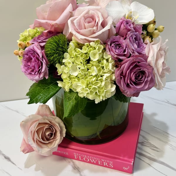 Pink and lavender roses with hydrangea in a glass vase