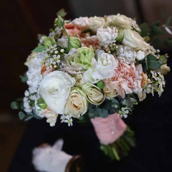 Hand-tied bouquet of white, blush, and peach flowers