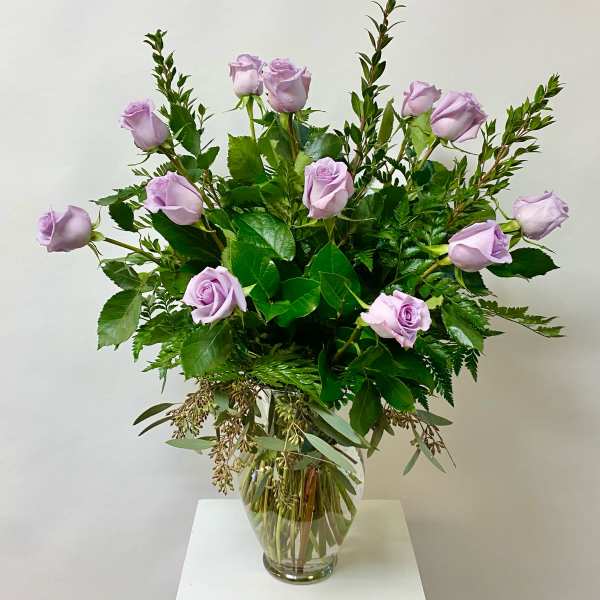 Lavender roses arranged in a clear glass vase