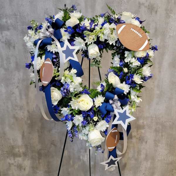 Heart-shaped floral wreath with blue ribbons, stars, and football accents