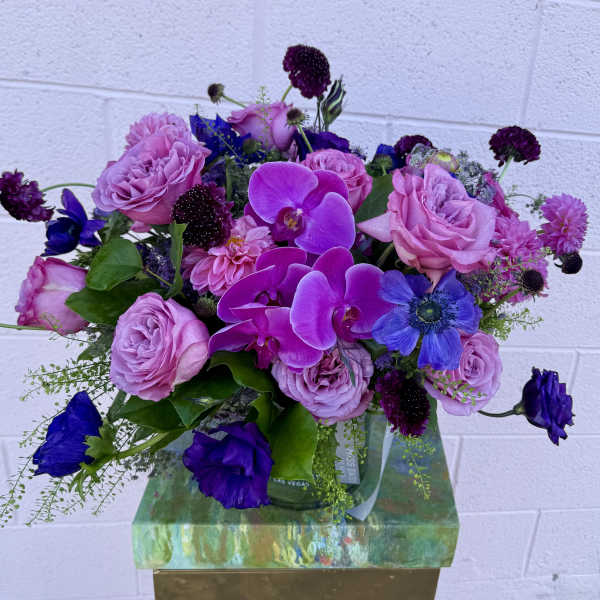 Bouquet of pink roses and purple orchids in a glass vase